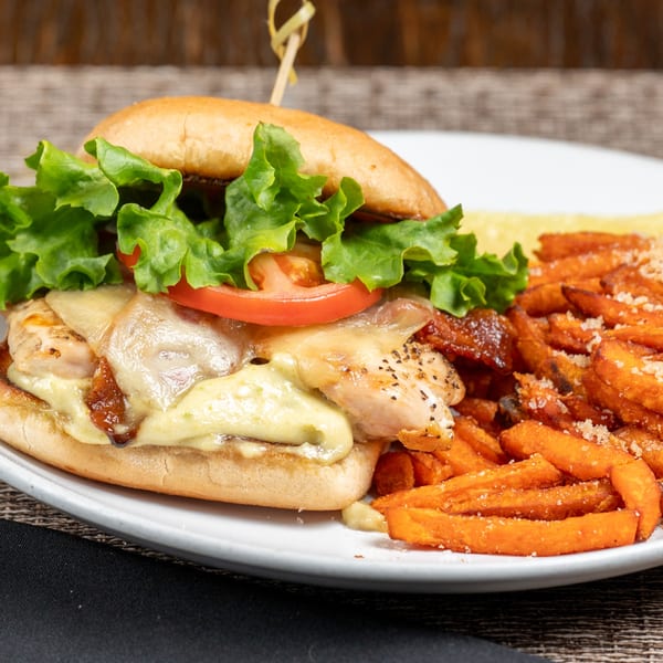Foster's on the Point chicken sandwich with melted cheese, lettuce, tomato, and sweet potato fries.